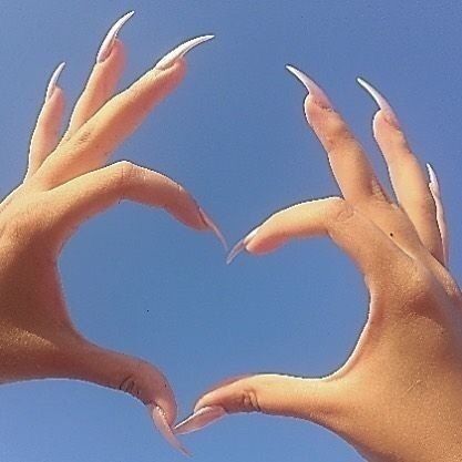 two hands in the shape of a heart against a blue sky with one hand extended out