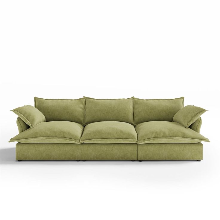 a green couch with two pillows on it and one pillow is folded over the back