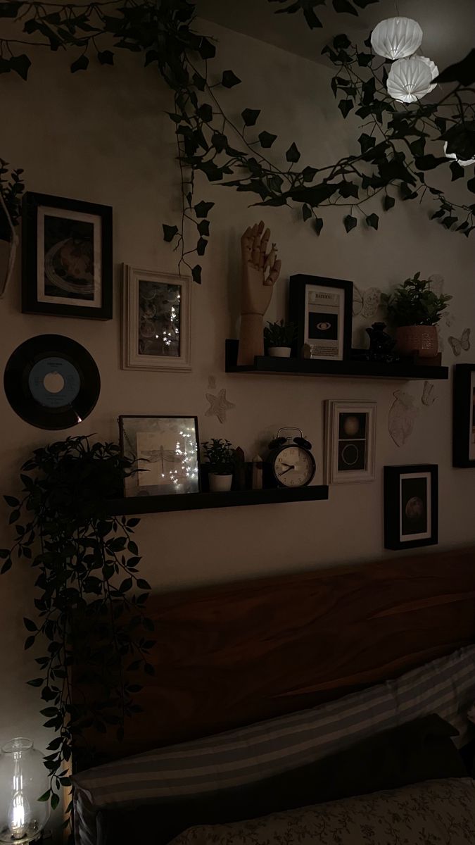 a bed room with a neatly made bed and lots of pictures on the wall above it