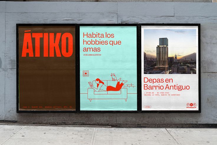 three posters on the side of a building with buildings in the background and a person walking by