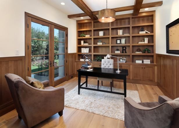 a living room filled with furniture and lots of wooden bookshelves next to a window