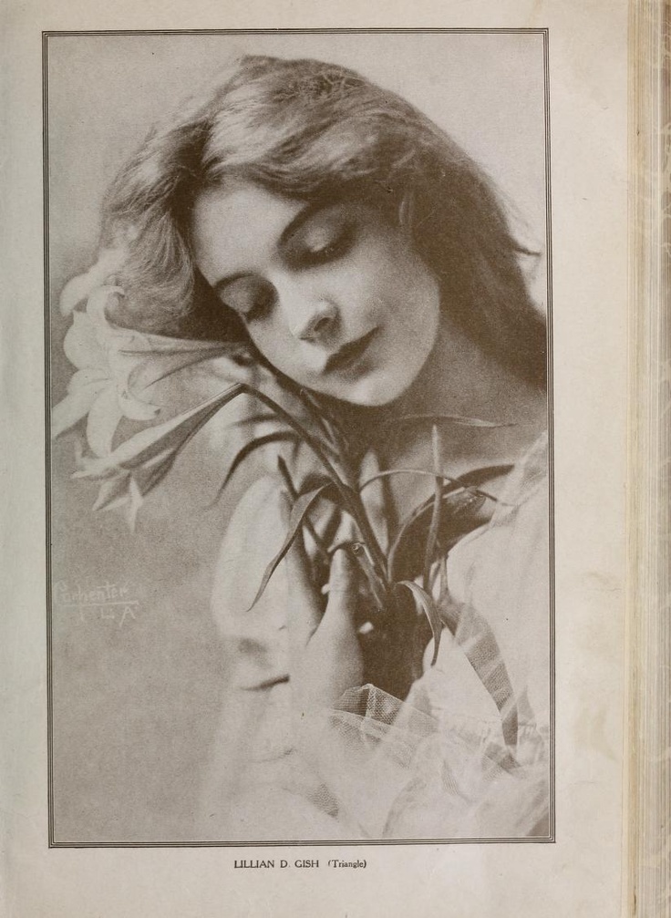 an old black and white photo of a woman holding flowers