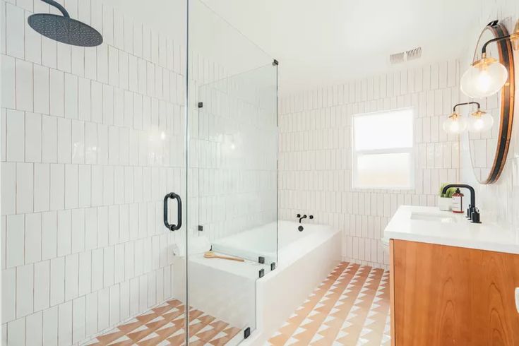 a bathroom with a sink, mirror and bathtub next to a shower stall in the corner