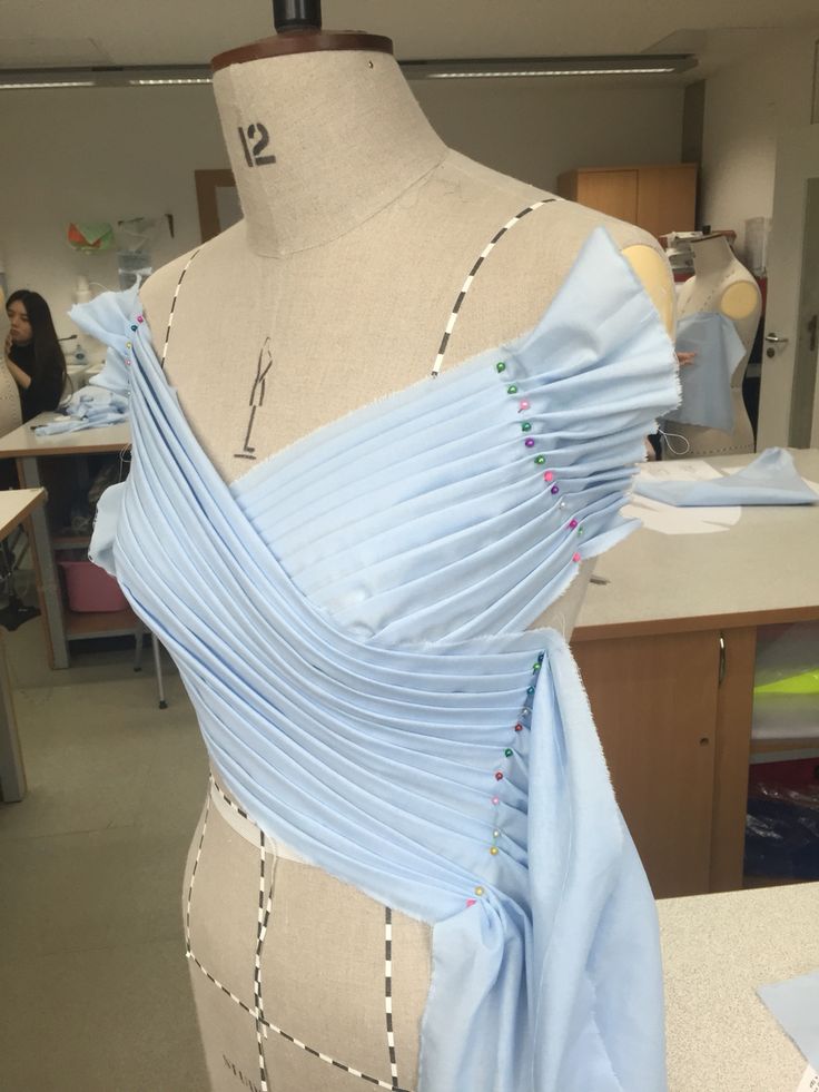 a dress on a mannequin in an office setting with people working behind it