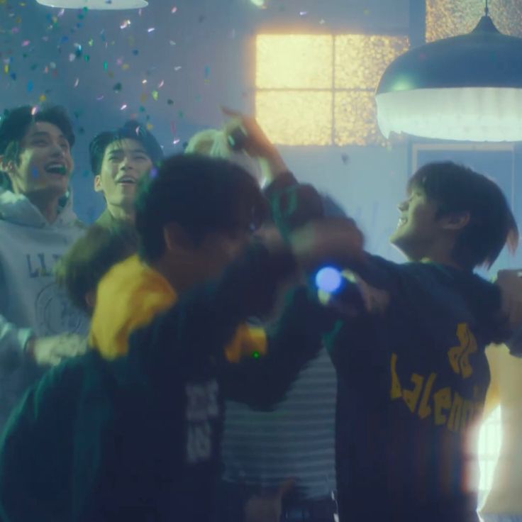 a group of young men standing next to each other in front of confetti