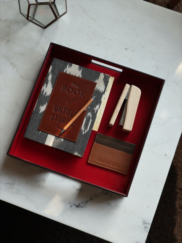 a red tray with a book and some other items on it