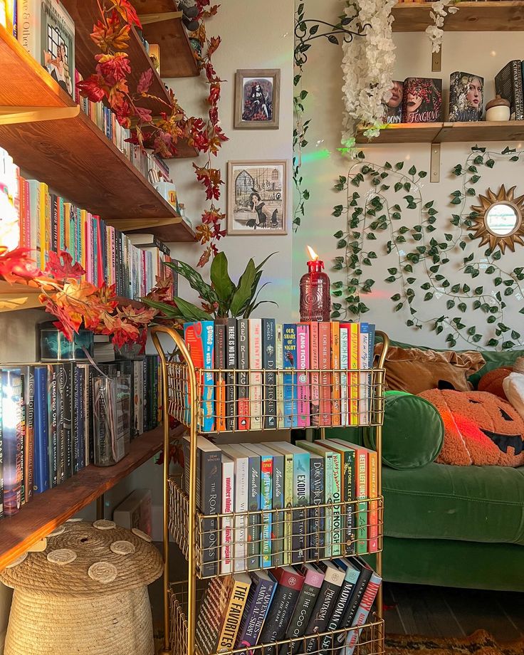 a bookshelf filled with lots of books next to a green couch in a living room