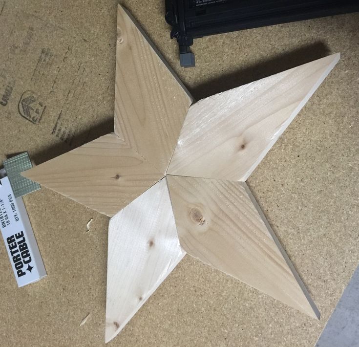 a wooden star sitting on top of a table next to a piece of wood with a tag