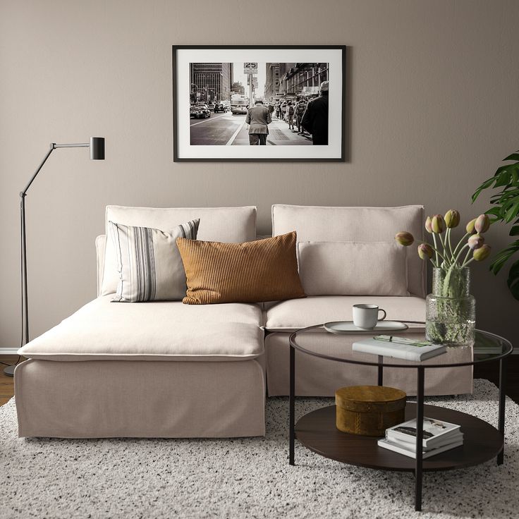 a living room with a couch, coffee table and pictures on the wall above it