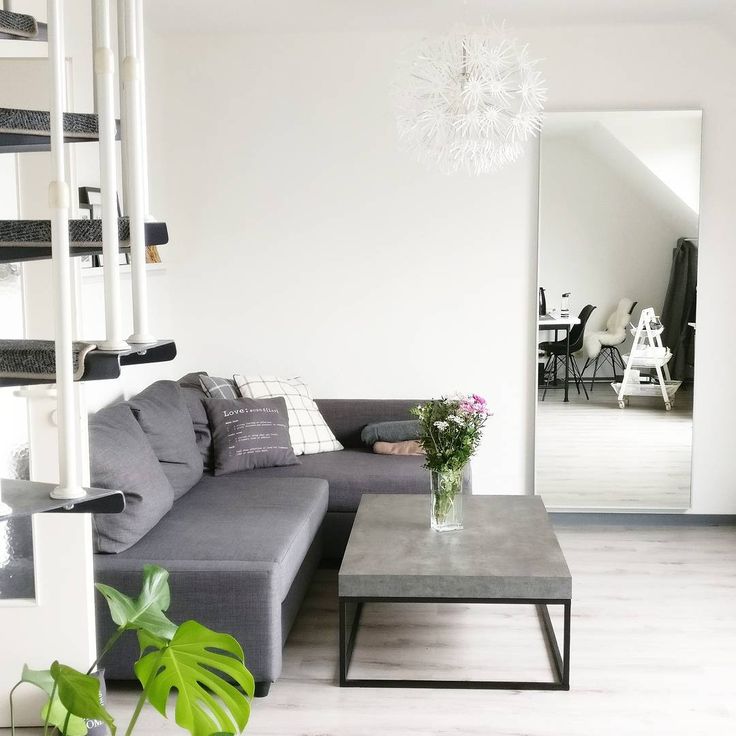 a living room filled with furniture and a plant in the middle of it's center