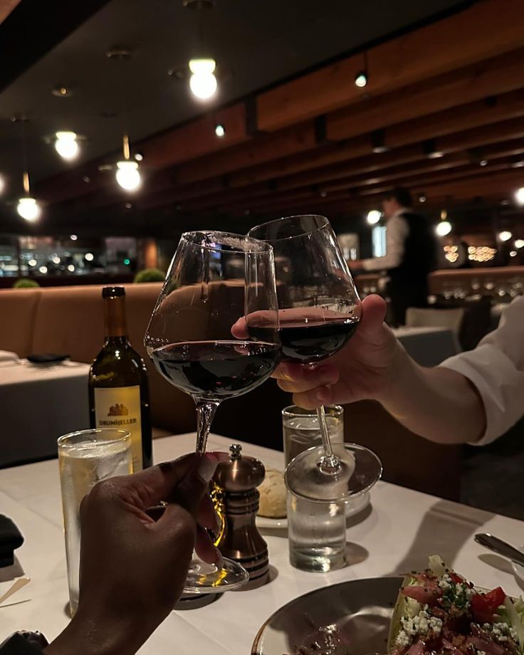 two people toasting wine glasses at a restaurant