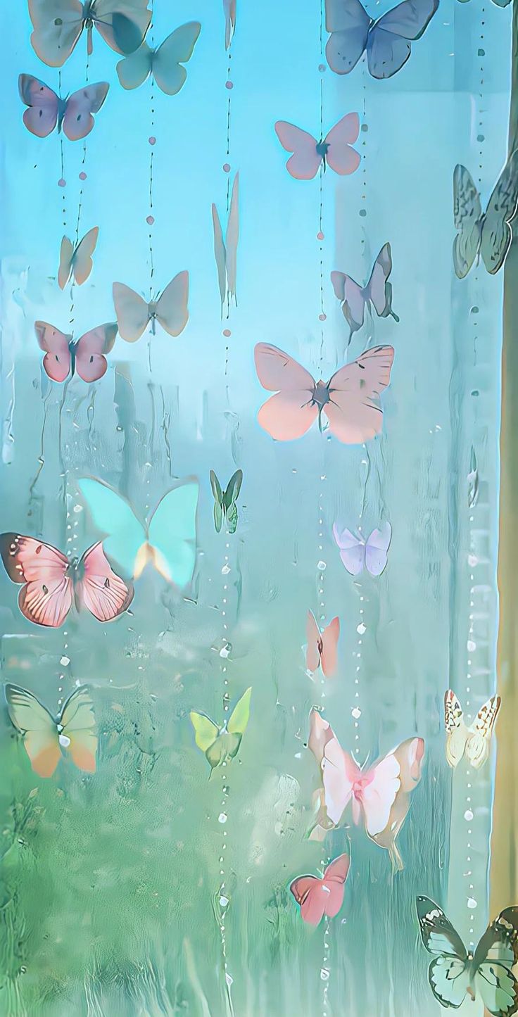 a bunch of butterflies are hanging from strings in front of a window with blue sky