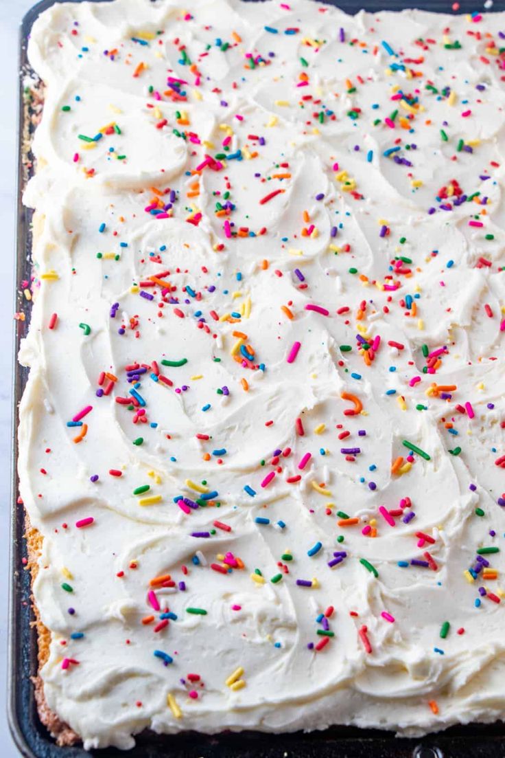 a cake with white frosting and colorful sprinkles