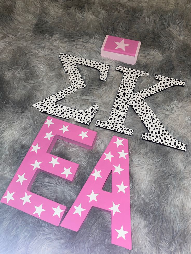 the letters are made out of paper and have white stars on them, as well as polka dots