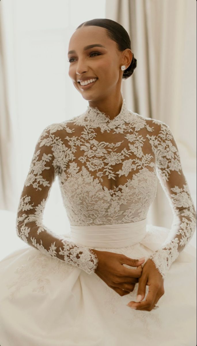 a woman in a white wedding dress smiling at the camera