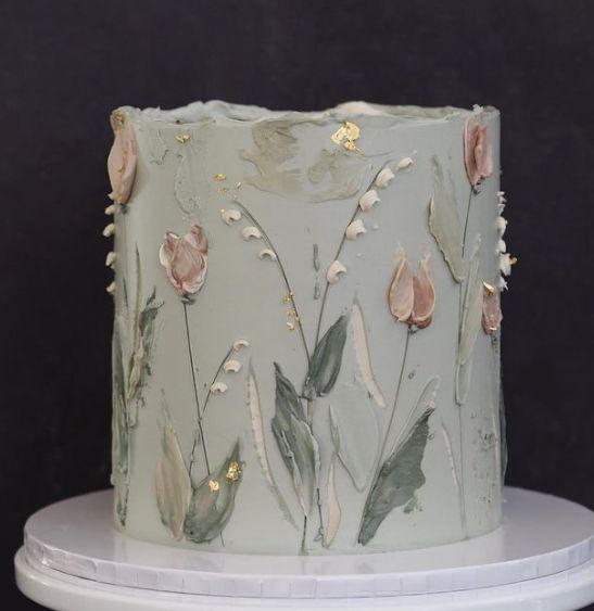 a frosted cake with flowers and leaves on it