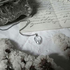 an antique silver box and some flowers on a white table cloth with writing in the background