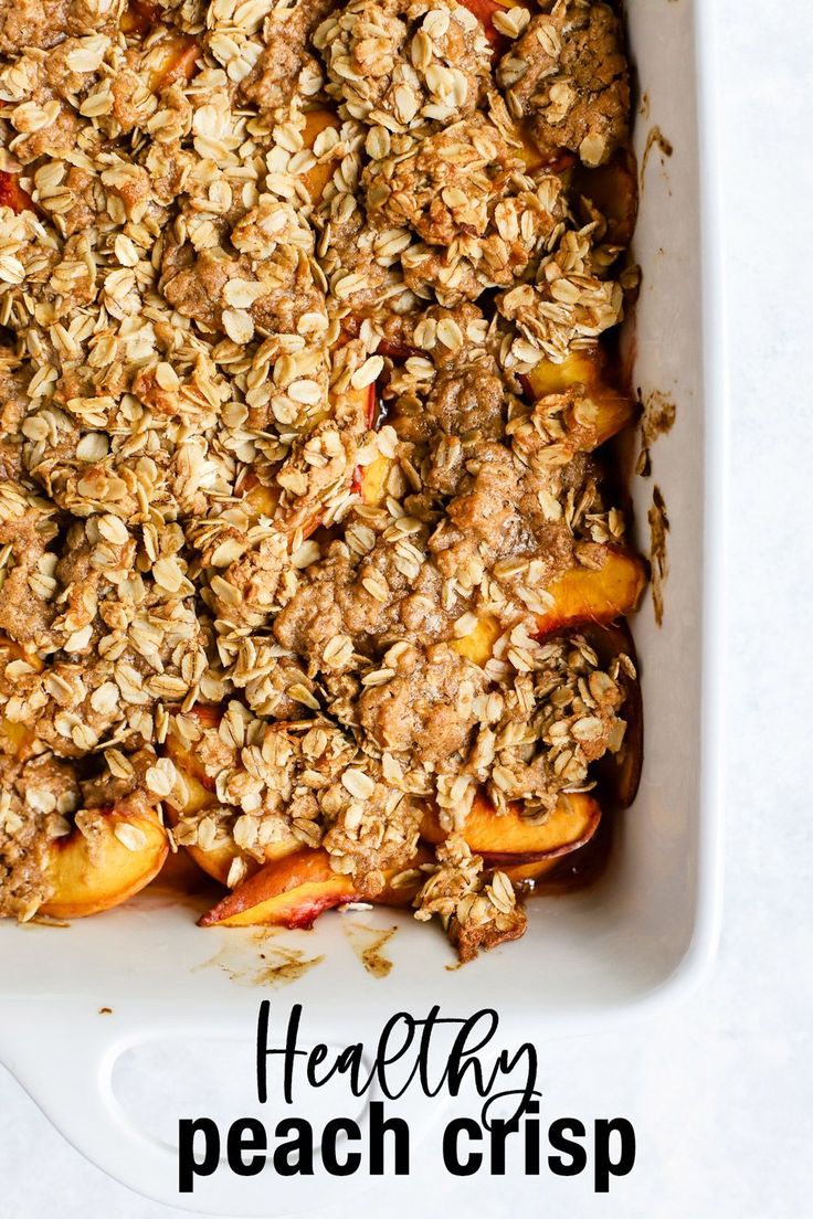 a white dish filled with granola and peaches next to the words healthy peach crisp