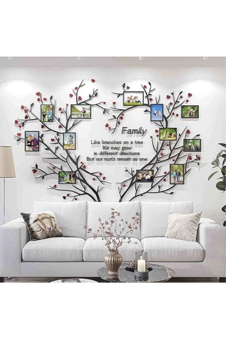 a white couch sitting under a tree with pictures on it