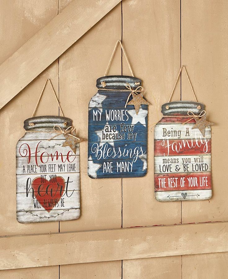 three painted mason jars hanging on a wall