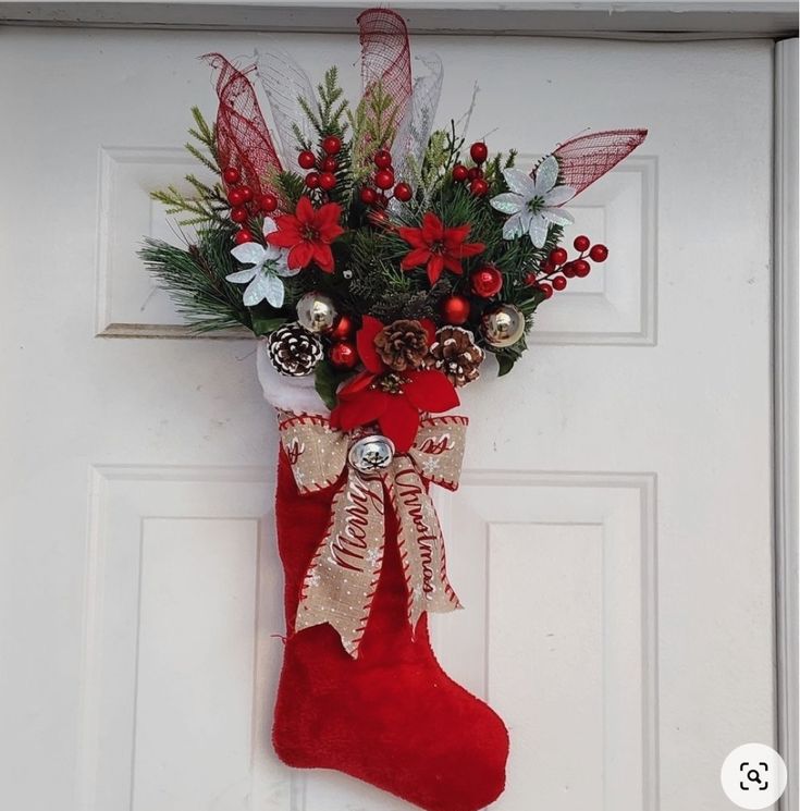 a christmas stocking hanging on the front door with bells and flowers in it,