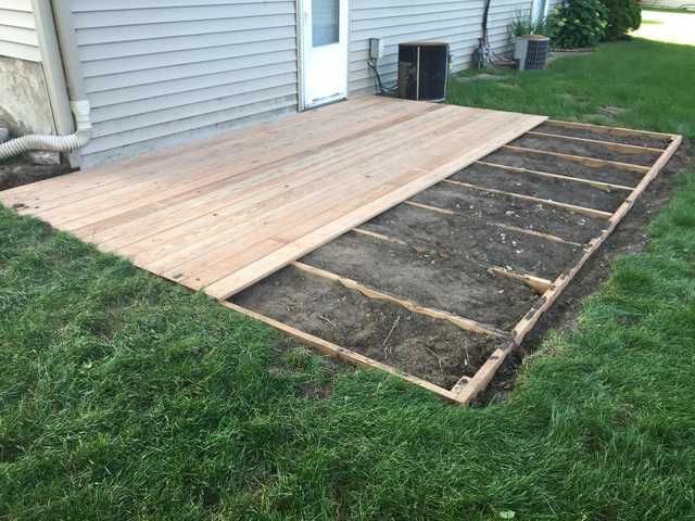 a wooden deck is being built in the grass