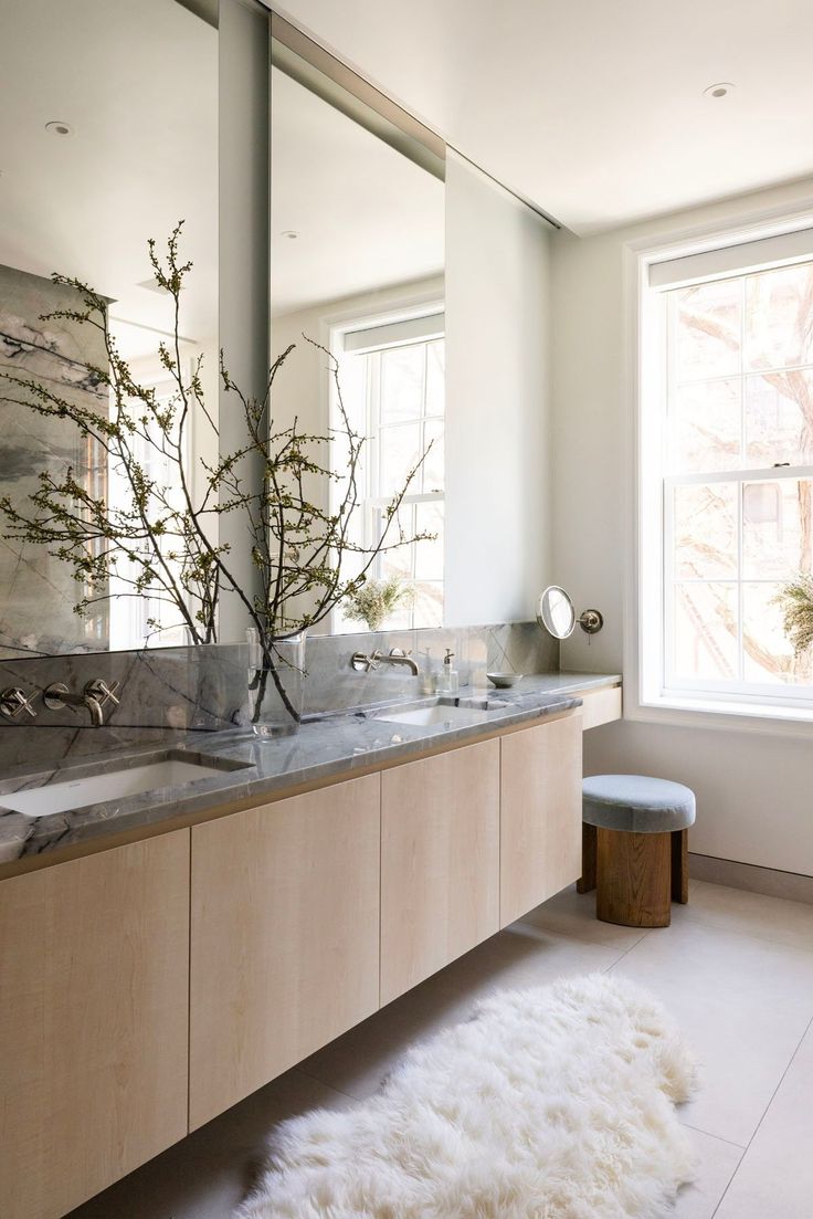 a bathroom with two sinks and a large mirror over it's counter top, along with a rug on the floor