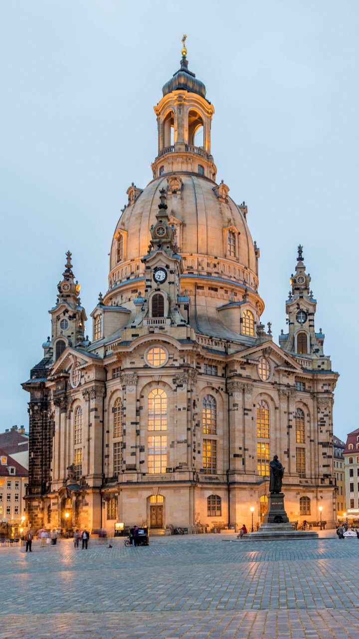 a large building with a clock on it's face in the middle of a square