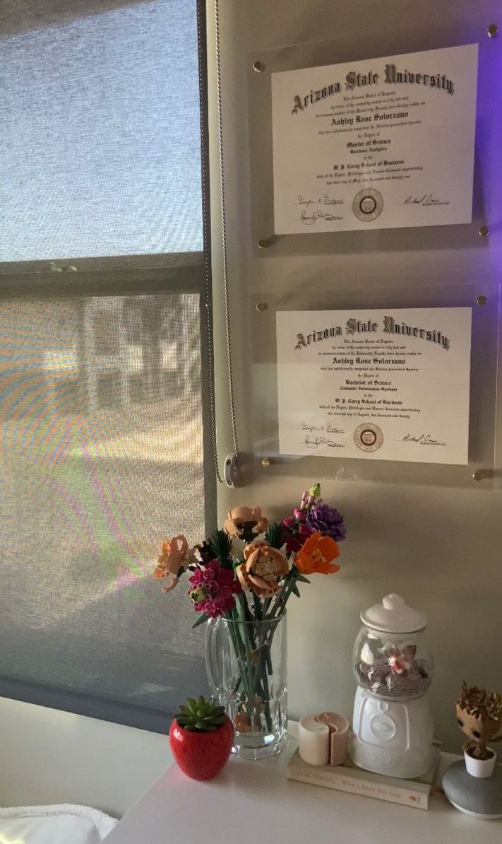 there is a vase with flowers on the table next to two signs that read arizona state university