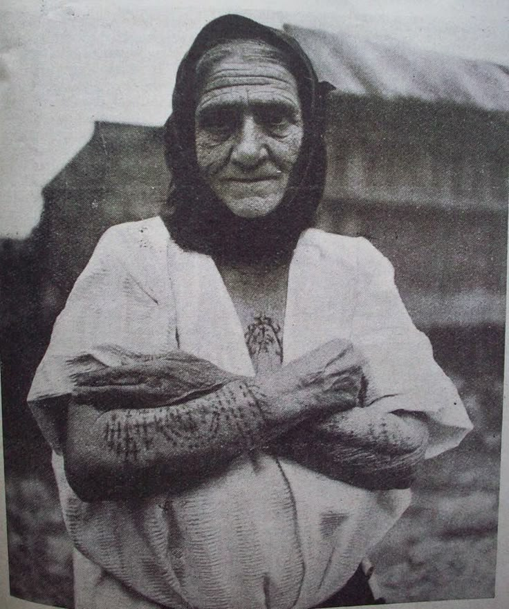 an old photo of a woman with her arms crossed and hands wrapped around her chest