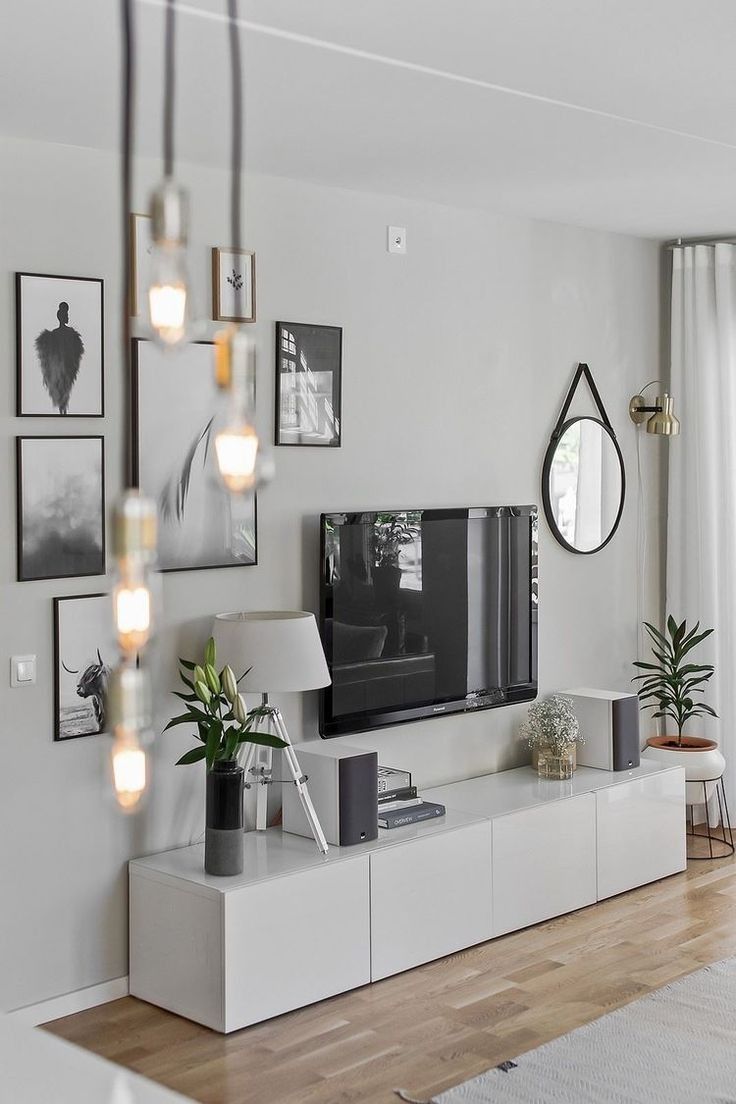 a flat screen tv sitting on top of a white entertainment center in a living room