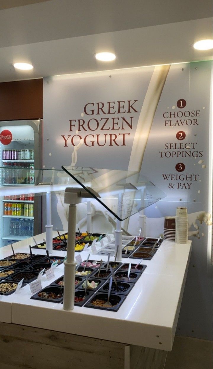 an ice cream shop with frozen yogurt and other items on the display counter