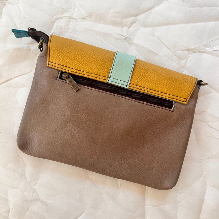 The saddle bag is sure to become your favorite companion while out and about, whether running arrands, sight-seeing, or dancing the night away! This wristlet is perfectly sized to carry your essentials and can be carried as a wristlet, used as a clutch, or attach the included adjustable leather strap and wear it as a crossbody. Saddle has a main zippered compartment that is covered by a colorful magnetic flap. Inside is a zip pocket and the the back has another zip pocket for easy access. 10" L x 7" H x 1.25" W Strap: Adjustable up to 50" Wristlet: 7.5" Long View entire Soruka collection This is a one-of-a-kind piece created, designed, and manufactured by hand using discarded, leftover, or no longer in use leather, in order to reduce the ecological impact of leather production. Adjustable Pouch Bags For Daily Use, Travel Shoulder Bag Clutch For Mobile Phone, Travel Phone Clutch Bag With Detachable Strap, Travel Handheld Clutch For Mobile Phone, Trendy Brown Clutch For Travel, Brown Handheld Pouch With Detachable Strap, Brown Clutch With Removable Pouch For On-the-go, Handheld Clutch With Adjustable Strap For Daily Use, Handheld Phone Bag With Detachable Strap For Travel