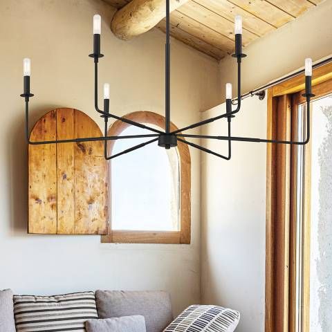 a living room filled with furniture and a large light fixture hanging over the top of it