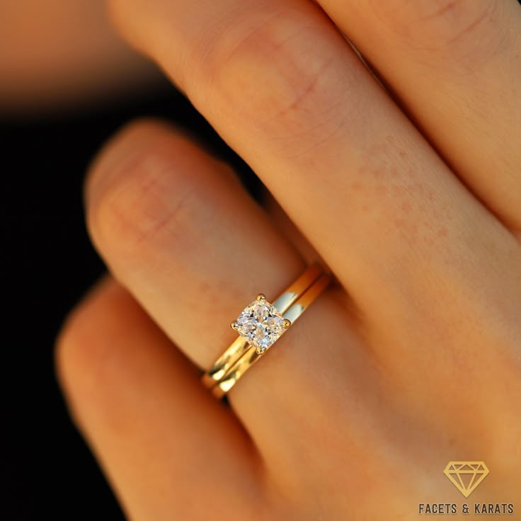 a woman's hand with a diamond ring on top of her finger and the other hand holding it