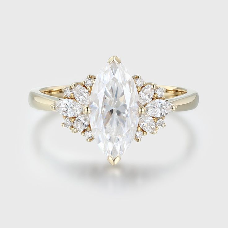 an engagement ring with a pear shaped diamond surrounded by small round diamonds on the band