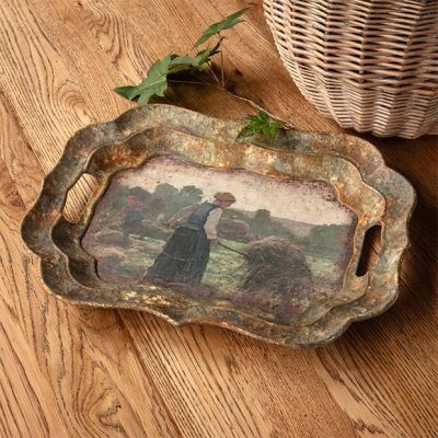 an old tray with a painting on it next to a wicker basket filled with leaves