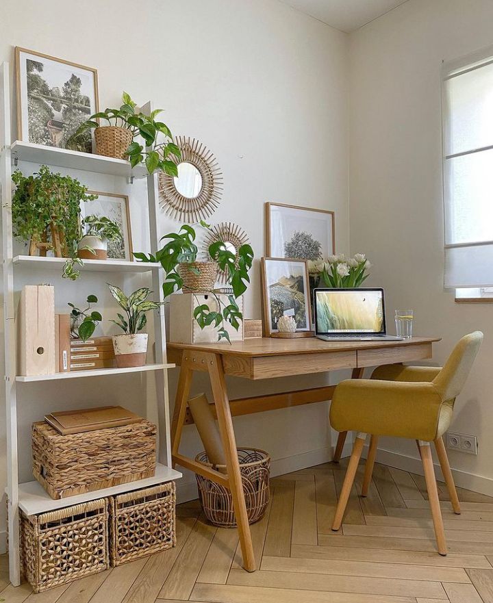 a wooden desk topped with lots of plants and wicker baskets next to a window