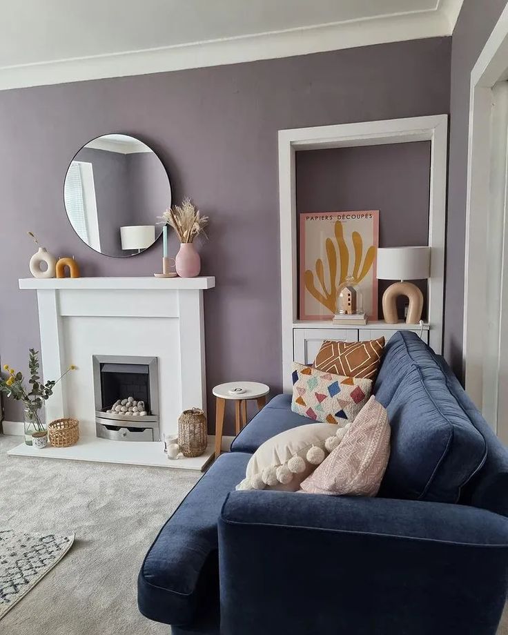 a living room filled with furniture and a fire place under a mirror on the wall