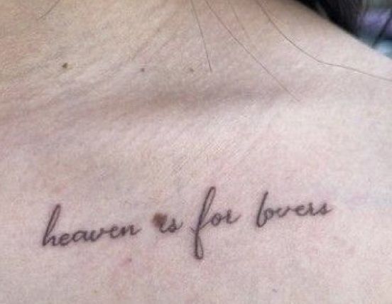 a woman with a tattoo saying heaven is for lovers on her chest and behind her back