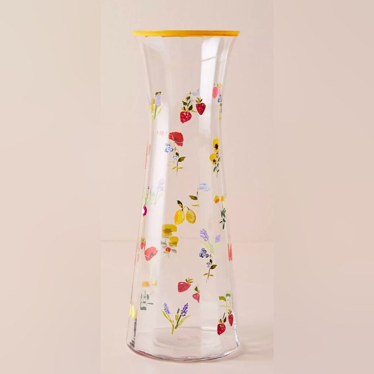 a glass vase with flowers and fruit painted on the bottom is shown in front of a white background