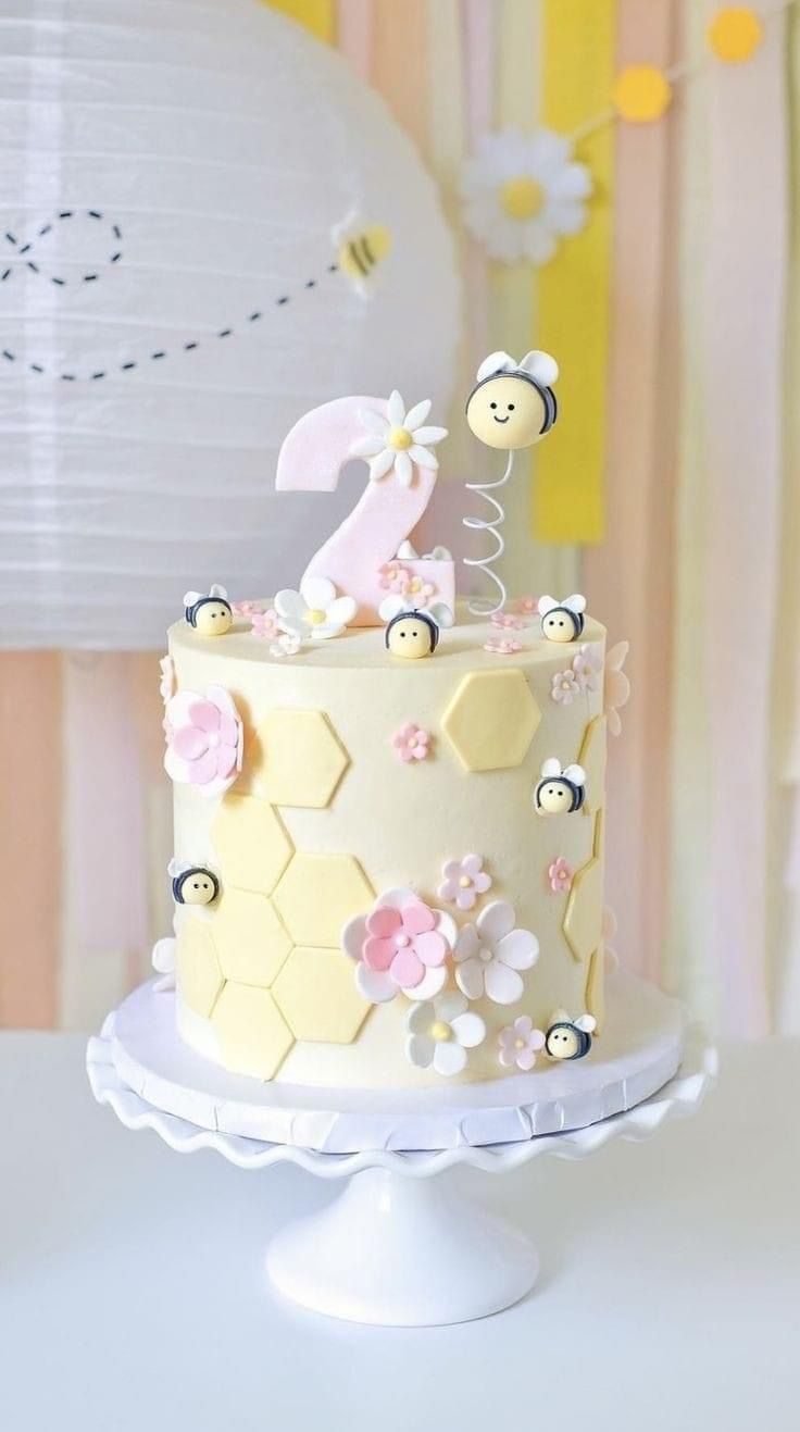 a cake decorated with bees and flowers on a table