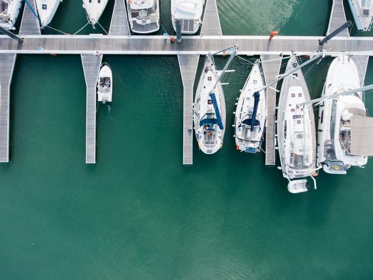 several boats are docked in the water at a dock