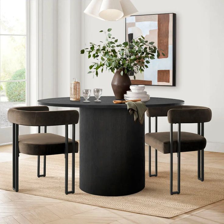 a dining room table with four chairs and a potted plant