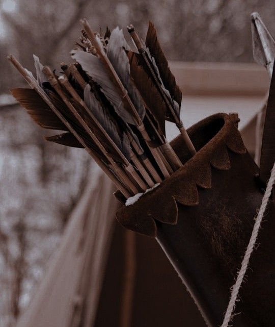 a bunch of arrows sticking out of the side of a brown bag on a window sill