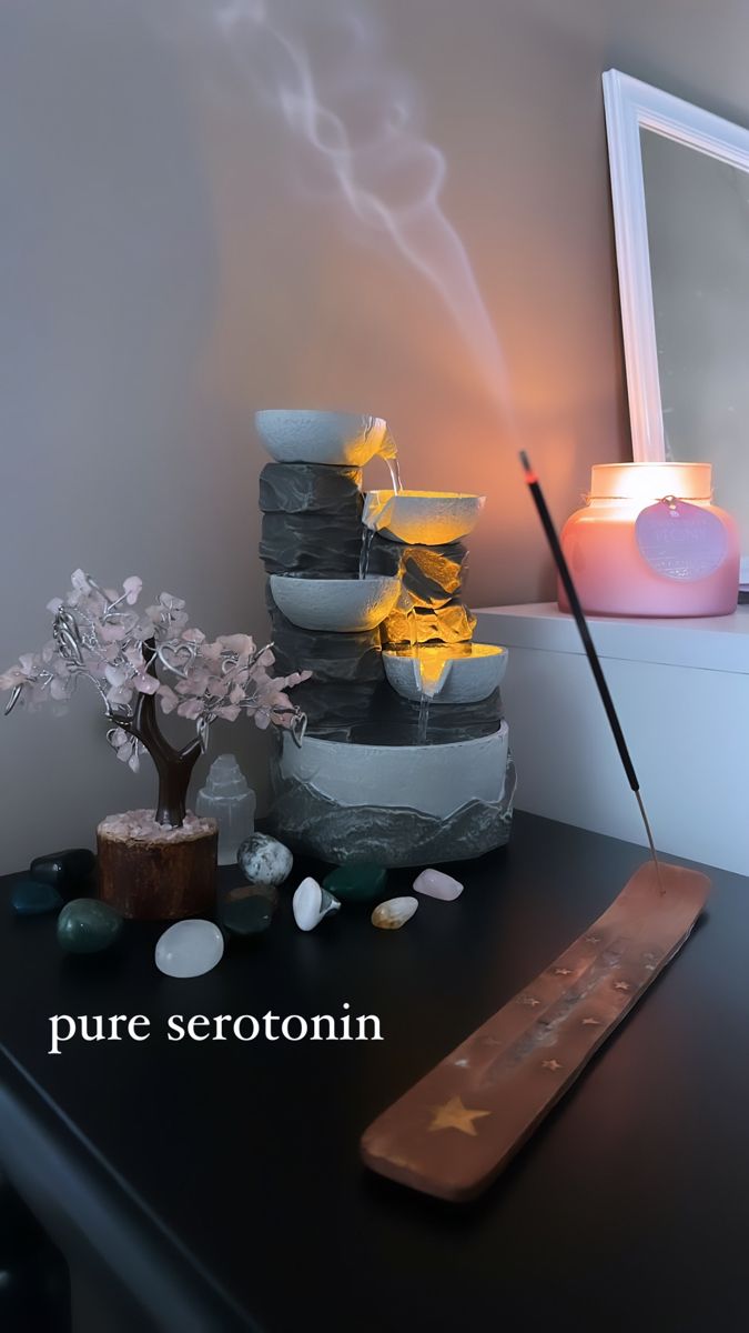 a black table with some rocks and candles on it, next to a candle holder