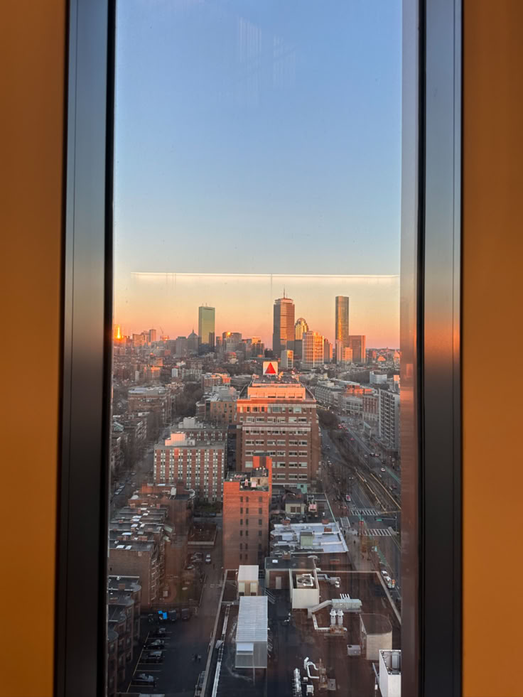 the city skyline is seen through a window