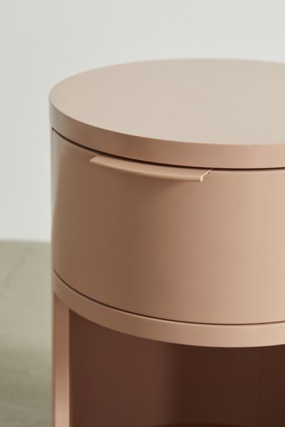 a close up of a round metal object on a table with a white wall in the background