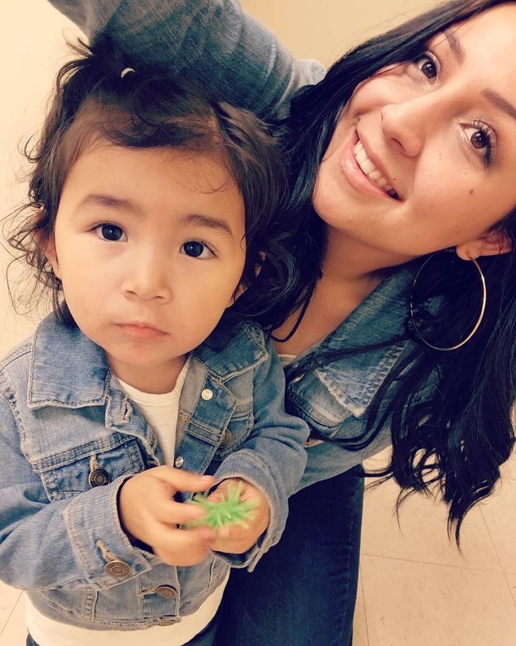 a woman is holding a small child in her arms while they both look at the camera