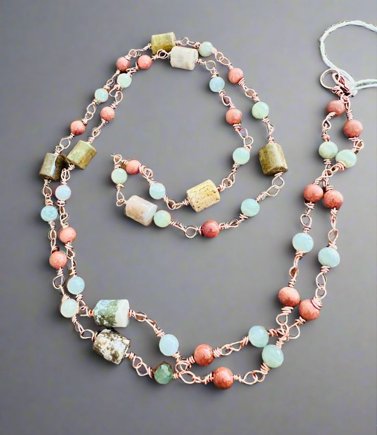 This beautiful, handmade necklace is sure to turn heads wherever you go! Crafted with jasper and goldstone, its adjustable up to 40-inches length makes it perfect for any occasion - whether you want to rock a choker, or just drape a stunning strand around your neck. Wrap it around your wrist for an unexpected bracelet - the possibilities are endless! Bohemian Beaded Aventurine Necklaces, Bohemian Jasper Wire Wrapped Necklaces, Bohemian Single Strand Agate Necklace, Bohemian Hand-wrapped Jasper Jewelry, Artisan Wire Wrapped Lariat Necklace, Adjustable Multi-strand Gemstone Necklace, Adjustable Copper Necklace With Natural Stones, Bohemian Aventurine Gemstone Bead Necklaces, Bohemian Aventurine Gemstone Beaded Necklaces